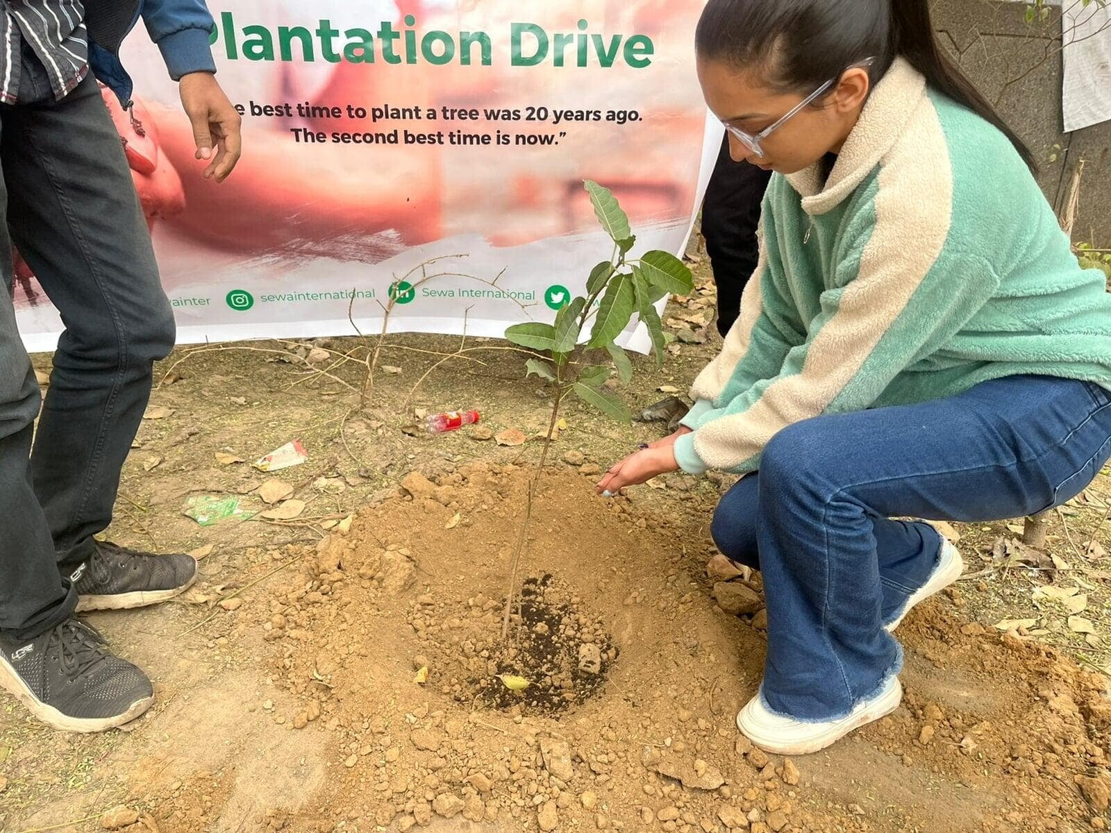 Sewa International volunteers planting saplings during a community plantation drive