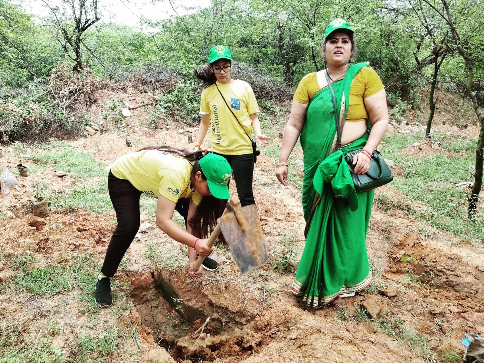Sewa International volunteers planting saplings during a community plantation drive