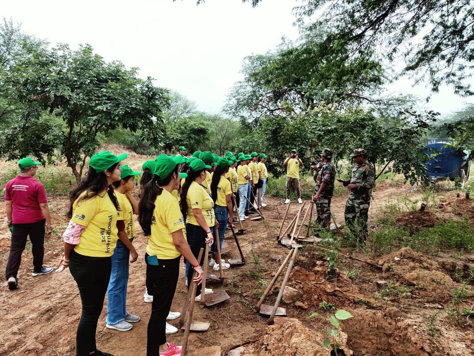 Sewa International volunteers planting saplings during a community plantation drive
